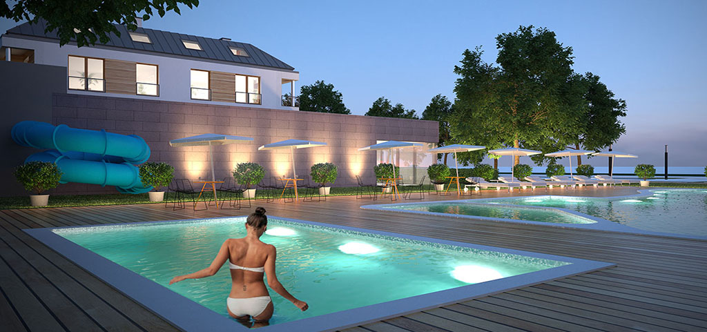 zdjęcie prezentuje luksusowy apartamentowiec z basenem nad morzem, w którym znajduje się oferowany na sprzedaż apartament