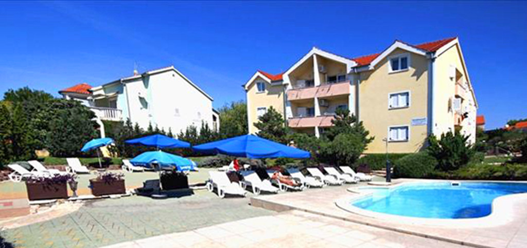 widok od strony basenu na luksusowy apartamentowiec w Chorwacji, w którym znajduje się oferowany na sprzedaż ekskluzywny apartament